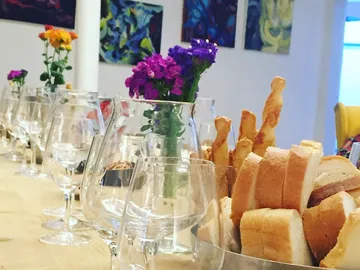 Glasses and bread are on a table with flowers.