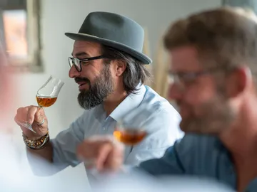 Man with a glass enjoying a drink in good company.