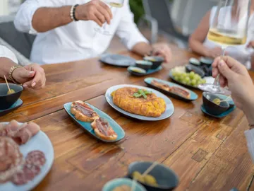 Tisch mit Essen, Menschen genießen Getränke und Lebensmittel.