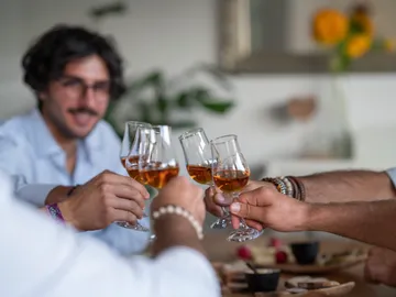 Glasses rise up to toast in good company.