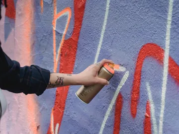 Hand spray graffiti on colored wall.