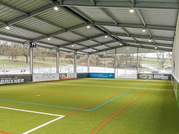 Small soccer facility plays on green, artificial turf.