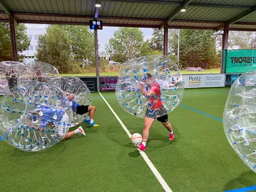 Spieler in Sicherheiten rollen auf einem Fußballplatz.