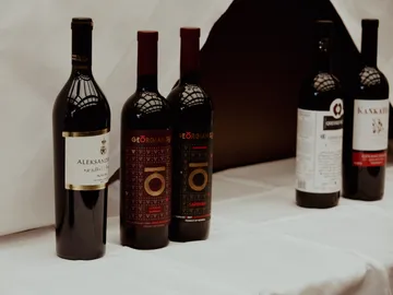 Wine bottles are placed on a table with a white ceiling.