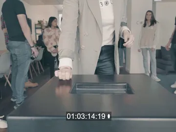 A person places their hand on a table.