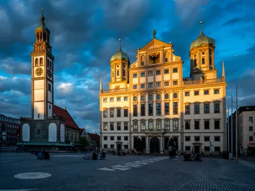 Historisches Gebäude mit Türmen, Licht spielt auf Fassaden.