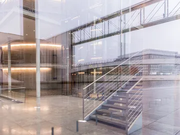Treppenhaus reflektiert, Verbindung zwischen Innenraum und Außenumgebung.