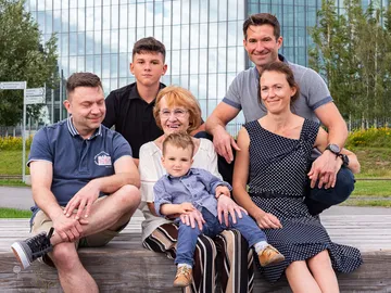 Familiengruppe sitzt draußen, Wolkenkratzer-Hintergrund in der Stadt.