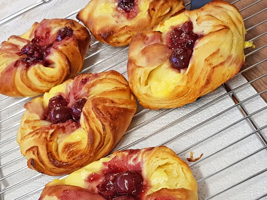 Cherry pastries cooling on wire rack.