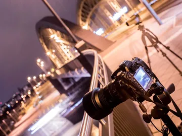 Camera on a tripod, footage of a bridge at night.