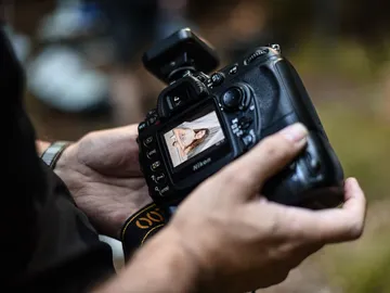 Kamera in Hand, zeigt Bild einer Person im Freien.