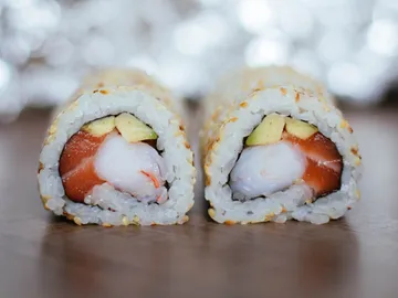 Sushi-Rollen liegen auf einem Tisch, schön präsentiert.