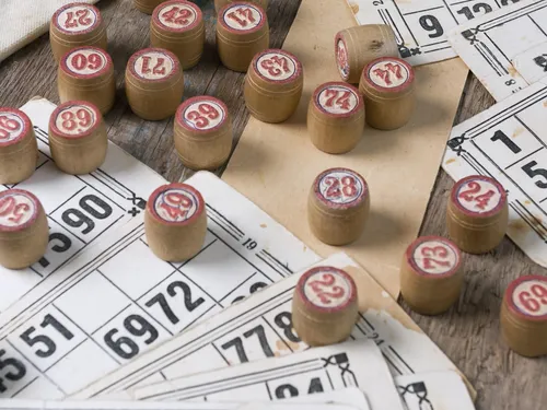 Wooden game pieces are scattered on bingo playing cards.