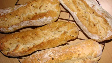 Fresh bread is laid out on a cake rack.