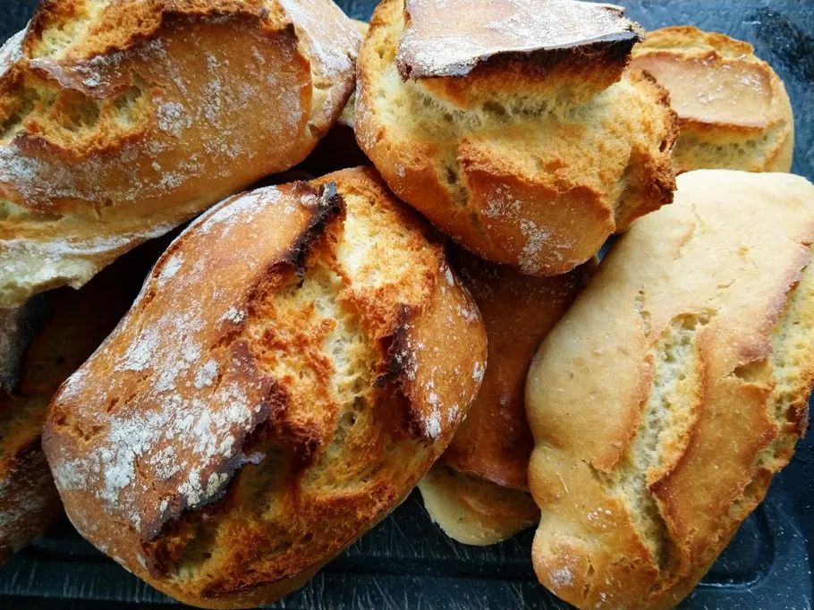 Fresh rolls lie on a dark surface.