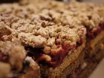 Cake with a crumbly top is laid out on a table.