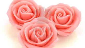 Three pink rose petals made of sugar, artfully designed.