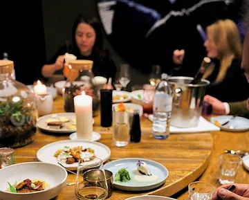 Elegante Dinner-Tische mit verschiedenen Gerichten und Kerzenlicht.