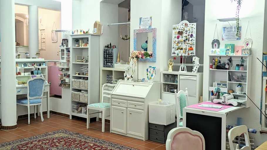 Bastelstudio mit Regalen, Schreibtischen und Zubehör.