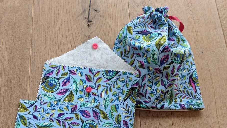 Colorful fabric envelope and pouch on wood surface.