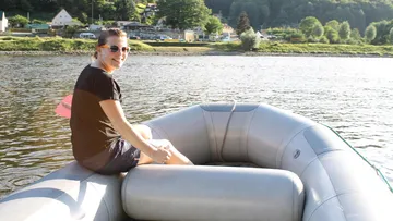 Person sitzt im Schlauchboot und genießt den Wasserblick.