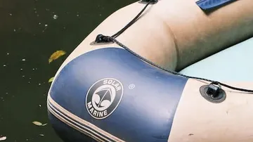 Gummiboot schwimmt ruhig auf einem Gewässer.