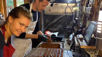 Two people make chocolate chocolates in a kitchen.
