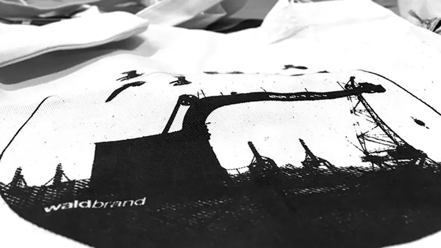 A tote bag with a black and white crane design.