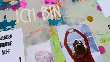 Bunte Collage mit Person, die Herzform zeigt.