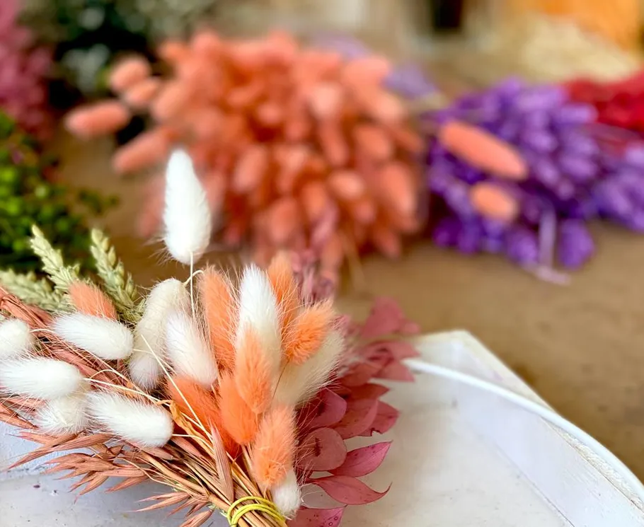 Colourful dried flowers arranged on a white plate.