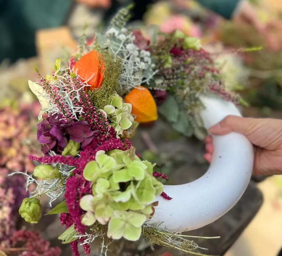 A blooming wreath is held in the hand.