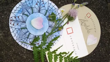 Zentangle-Muster und Naturmaterialien auf einer Oberfläche arrangiert.