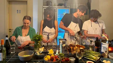 Chefs prepare food in a modern kitchen environment.