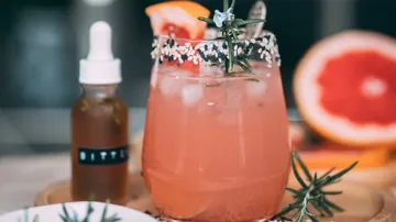 Ein Cocktail mit Eis und Fruchtstücken in einem Glas.