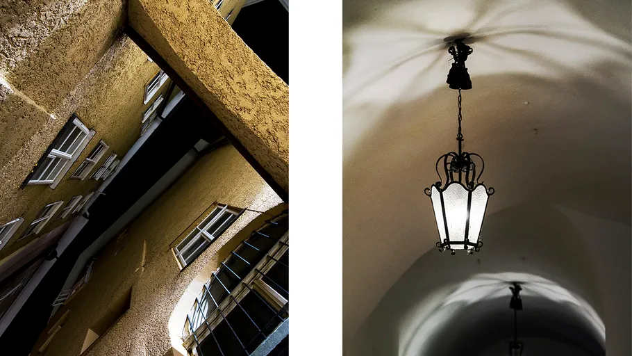 Bright lantern glows in a dark corridor with shadows.