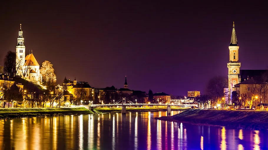 Night view of city with illuminated church towers.