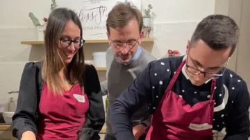 Drei Personen kochen gemeinsam in einer gemütlichen Küche.
