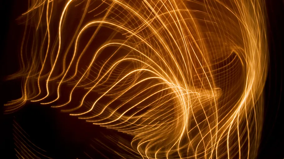 Abstract golden light trails on dark background.