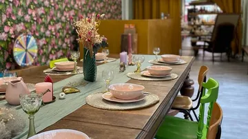 Oblong table with covered dishes in a colorful room.