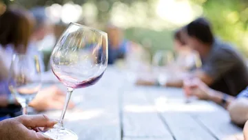 A glass of wine is held in good company.