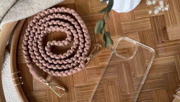 Lila Leine liegt auf einem Holztisch, neben einem durchsichtigen Handyhülle.