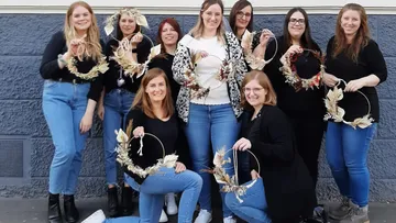 Group of women presenting handmade wreaths.