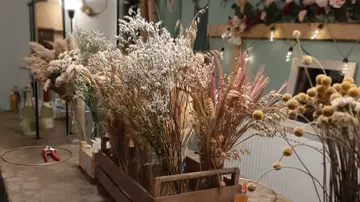 Dried flowers in a wooden box are decorative on a table.