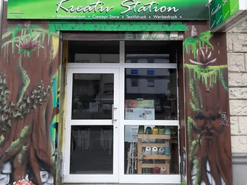Kreativstation mit einer farbenfrohen Wandmalerei und offenen Türen.