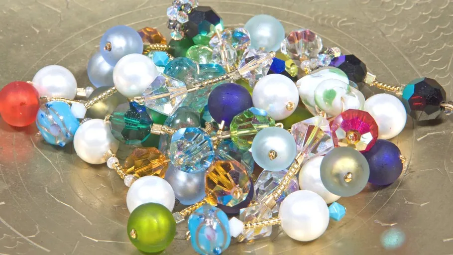 Colourful pearls are scattered on a flat surface.