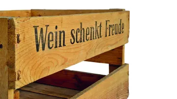 Wooden box stands, with the lettering “Wein schenkt Freude”.