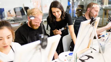 Four people paint on easels in a creative class.