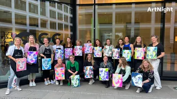 Group of women showing painted portraits in front of stained glass windows.