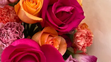 Bunte Blumenarrangement mit Rosen und Nelken im Fokus.