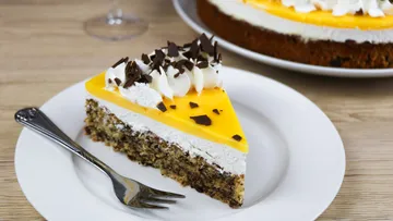 Piece of cake on a plate, with chocolate and cream.